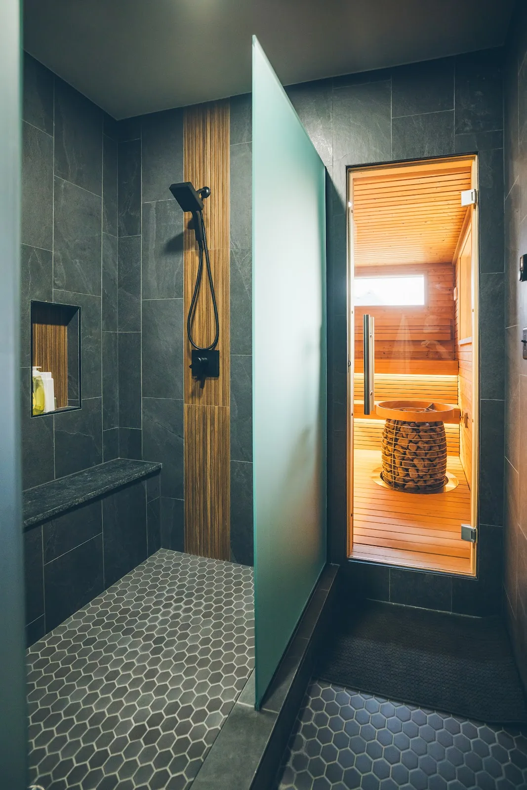 Chillfire Baltic wellness bath: the walk-in shower in the bath suite with the sauna glowing beyond its open glass door