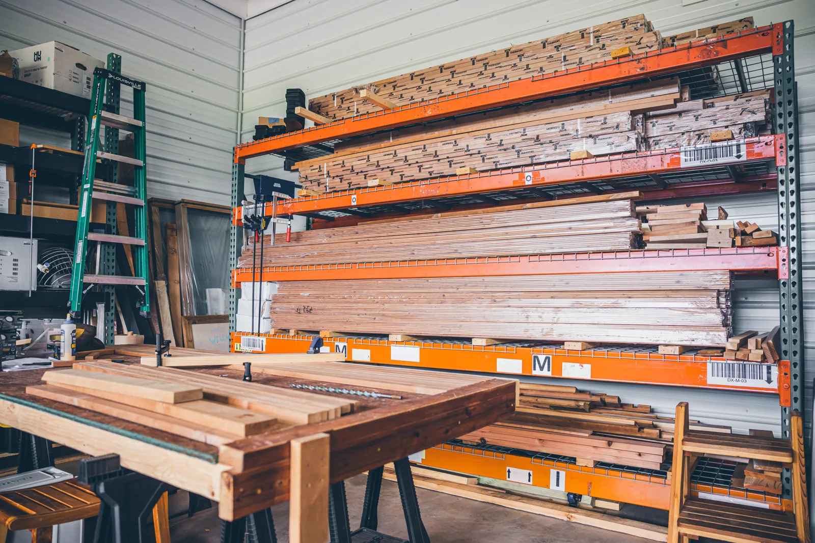 Angled view of loaded lumber racks and a workbench in the Chillfire workshop